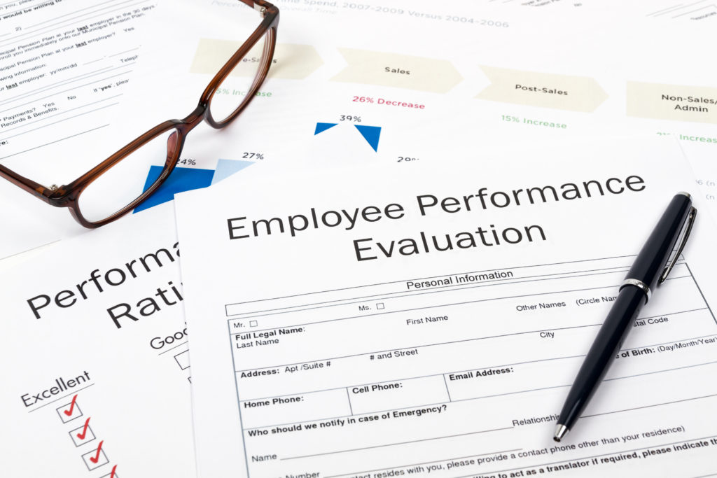 Hiring an employee? Glasses and Pen on Employee Performance Evaluation Sheets.