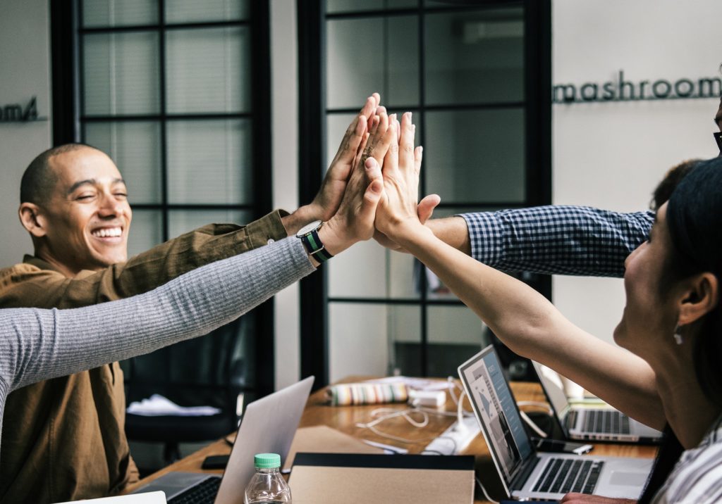 Hiring an Employee? Group of multicultural individuals high fiving one another